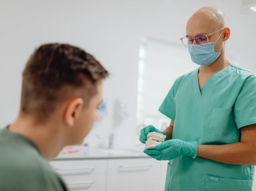 Dentist showing a patient a model of teeth in Cooma