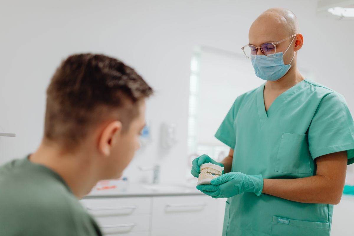 Dentist showing a patient a model of teeth in Cooma